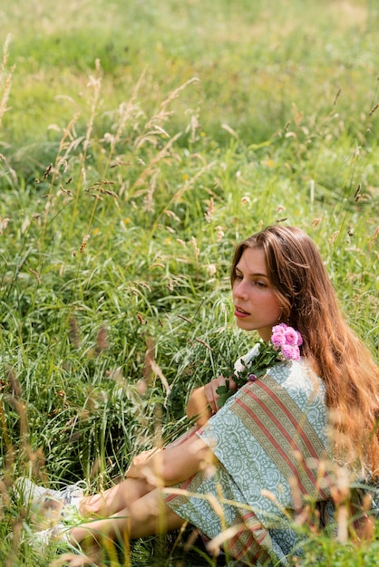 Full shot woman sitting on grass