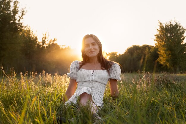 Full shot woman sitting on grass