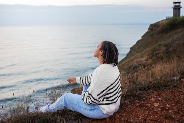 Free photo full shot woman sitting in nature