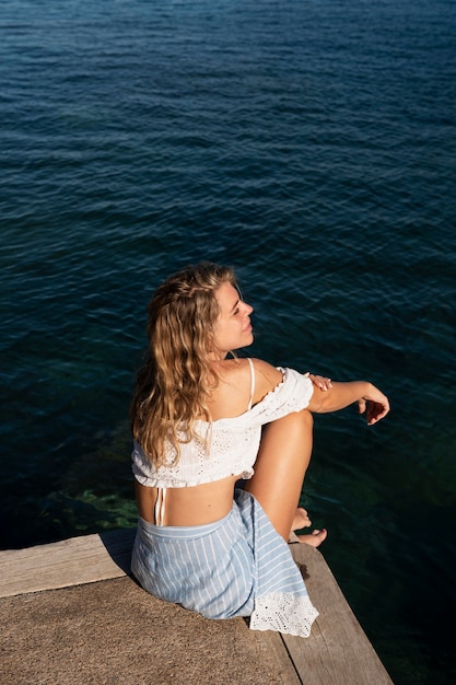 Free photo full shot woman sitting outdoors