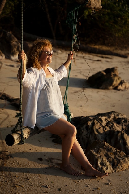 Free photo full shot woman sitting on a swing