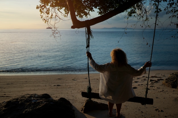 Free photo full shot woman sitting on a swing