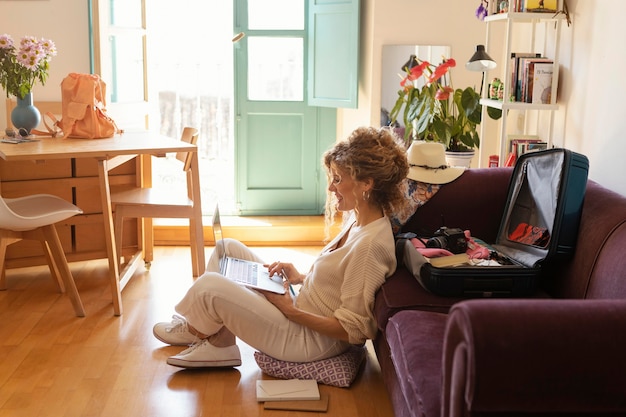 Full shot woman sitting with laptop