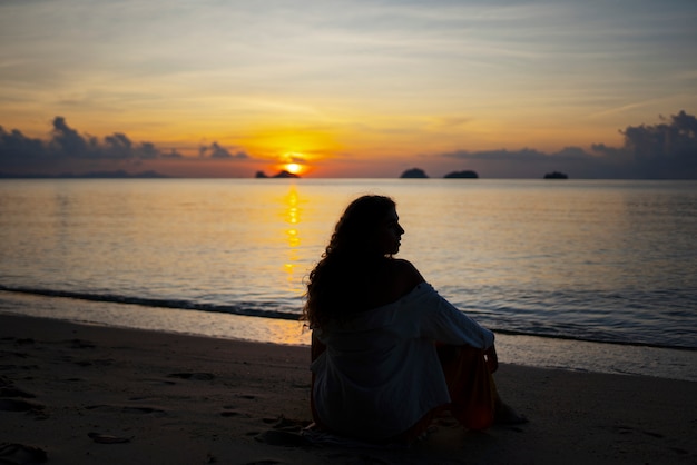 Full shot woman spending a day alone on the beach