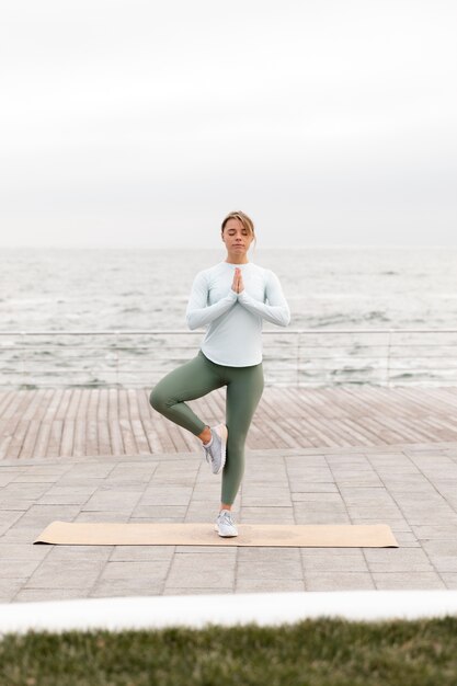 Full shot woman standing on one leg