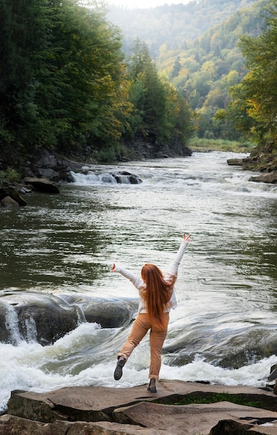 Free photo full shot woman standing on rock