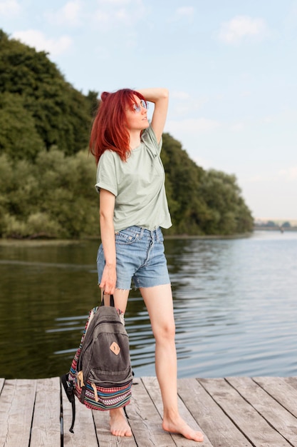 Free photo full shot woman staying on dock