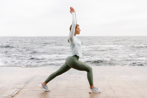 Full shot woman stretching on beach