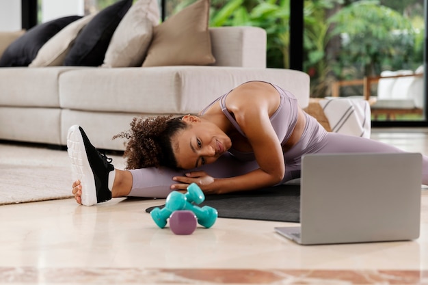 Full shot woman stretching at home