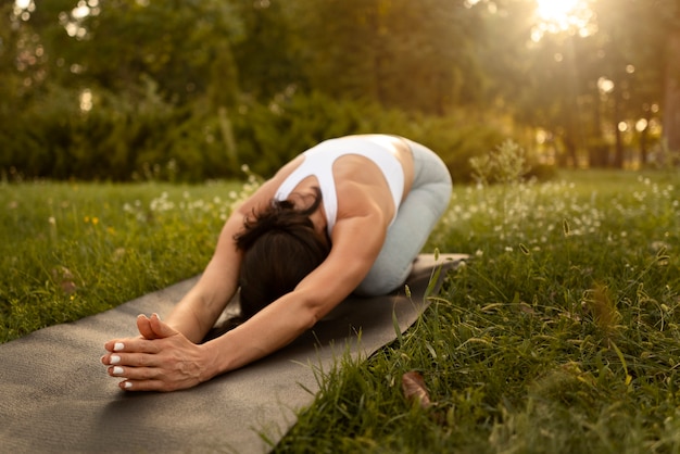 Full shot woman stretching on mat