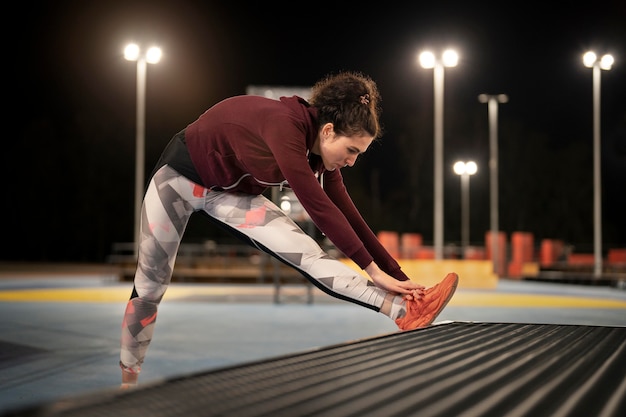 Free photo full shot woman stretching shoelaces