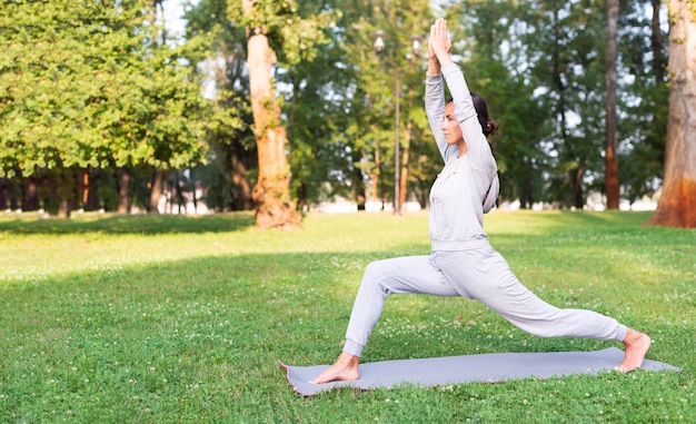 Full shot woman stretching on yoga mat