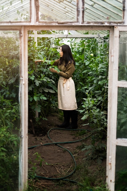 Free Photo full shot woman taking care of plants