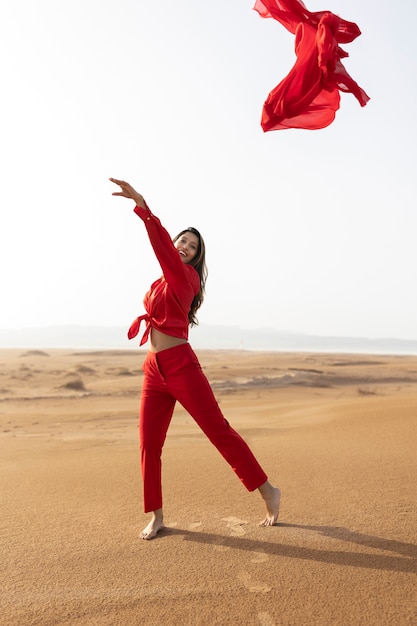 Free photo full shot woman throwing red scarf