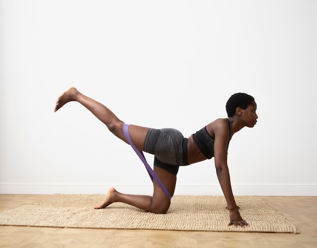 Full shot woman training with elastic band