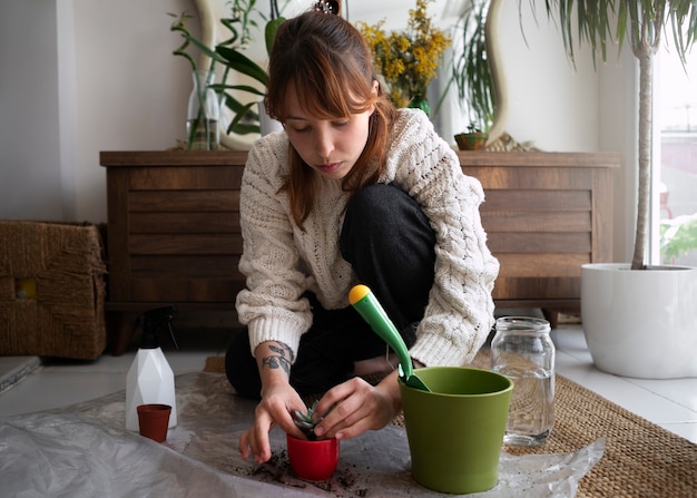 Full shot woman transplanting small plant