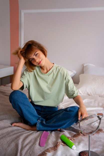 Free photo full shot woman using dry shampoo at home