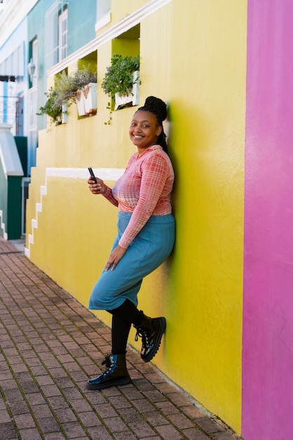 Full shot woman using smartphone outdoors