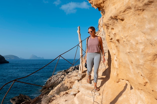 Free photo full shot woman walking on rock