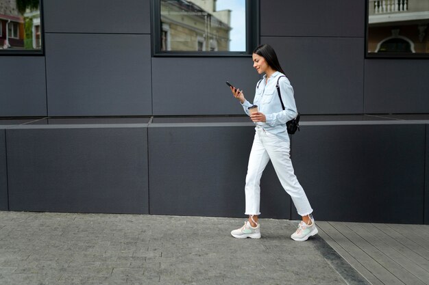 Full shot woman walking with device