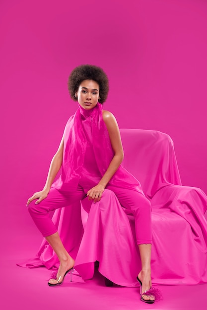 Free photo full shot woman wearing full pink outfit