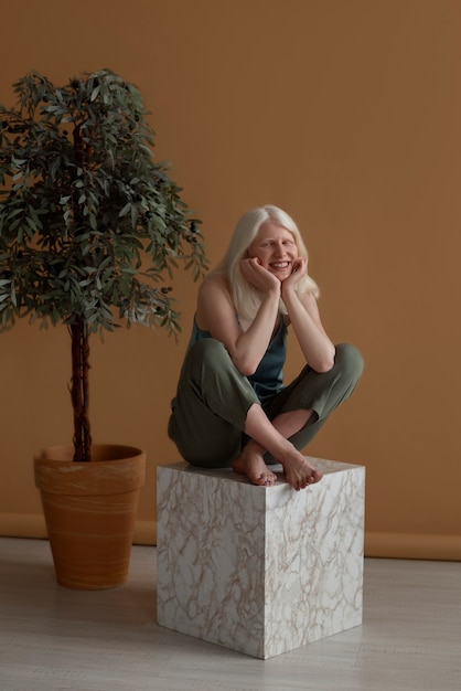 Free photo full shot woman with albinism posing in studio