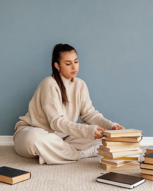 Free Photo full shot woman with books  on floor