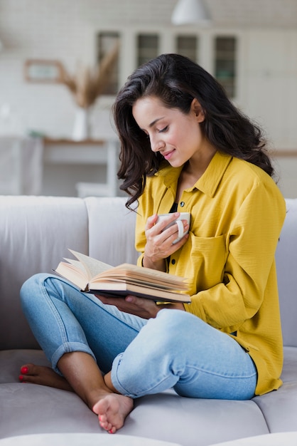 Full shot woman with cup and book