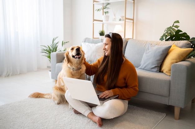 Full shot woman with dog and laptop