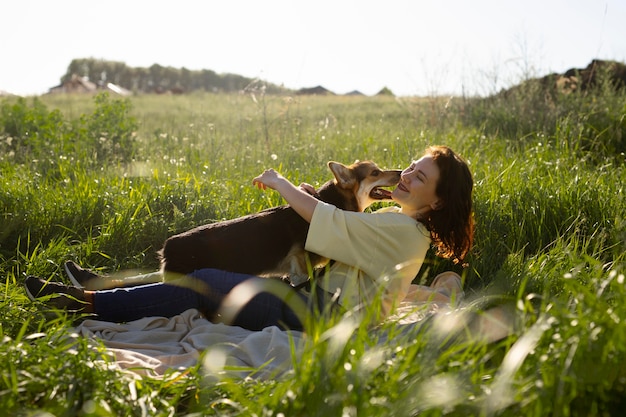 Full shot woman with dog in nature