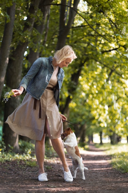 Free photo full shot woman with dog in park