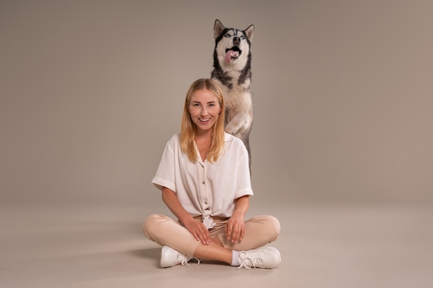 Free photo full shot woman with dog in studio