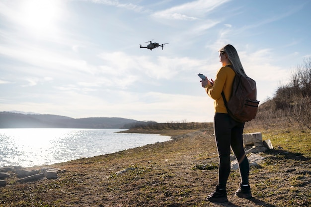 Full shot woman with drone outdoors