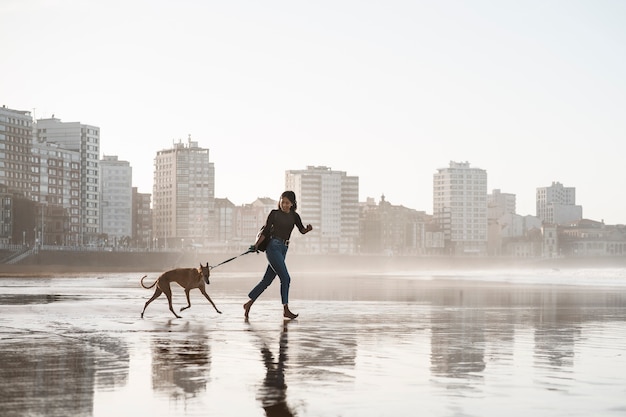 Free Photo full shot woman with greyhound dog outdoors