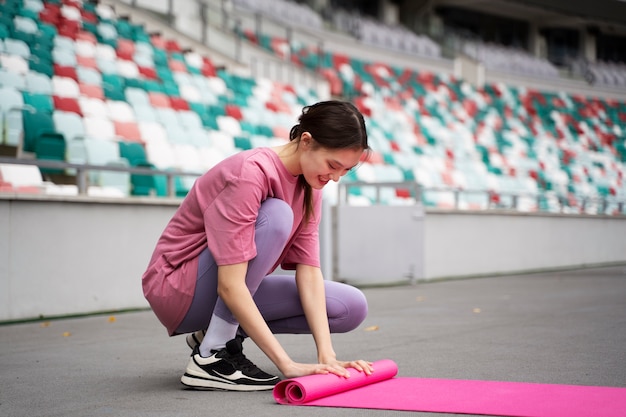 Full shot woman with yoga mat