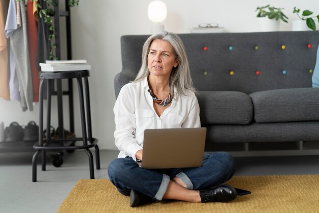 Full shot woman working on laptop indoors