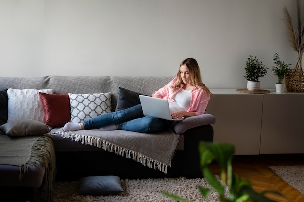 Full shot woman working with laptop