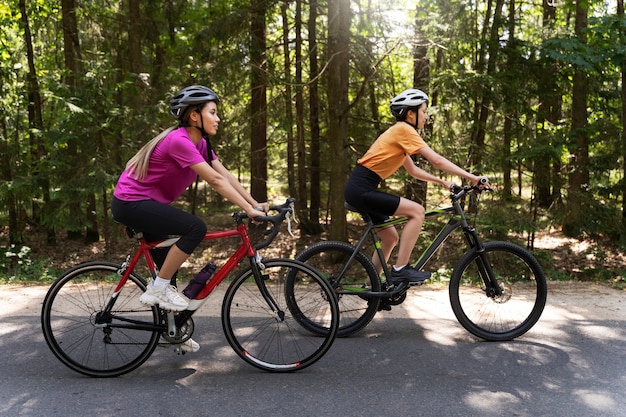 Free photo full shot women cycling together