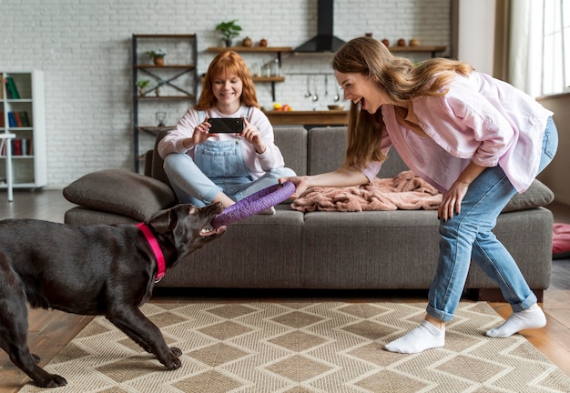 Free Photo full shot women and dog having fun