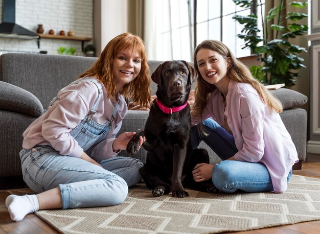 Full shot women and dog posing on floor