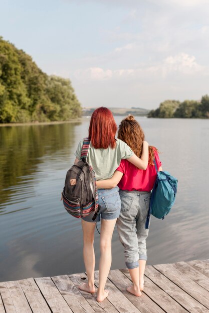 Full shot women hugging on dock