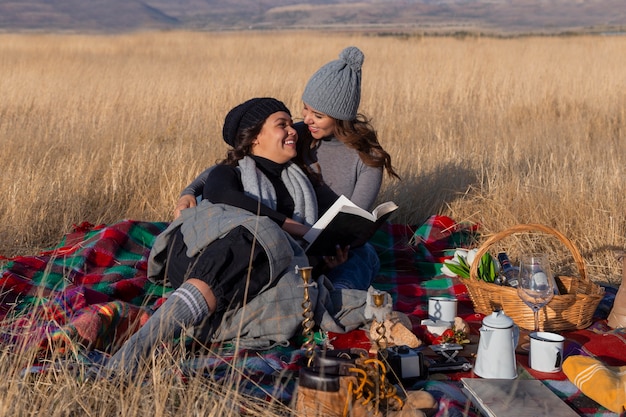 Full shot women laying on blanket outdoors