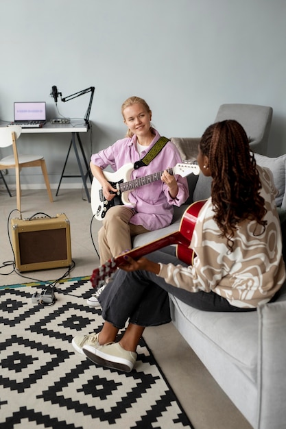 Free photo full shot women playing the guitar