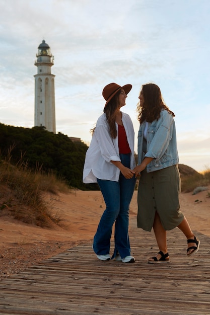 Free photo full shot women posing with lighthouse