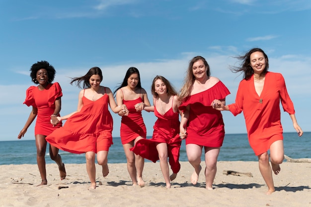 Full shot women running on beach