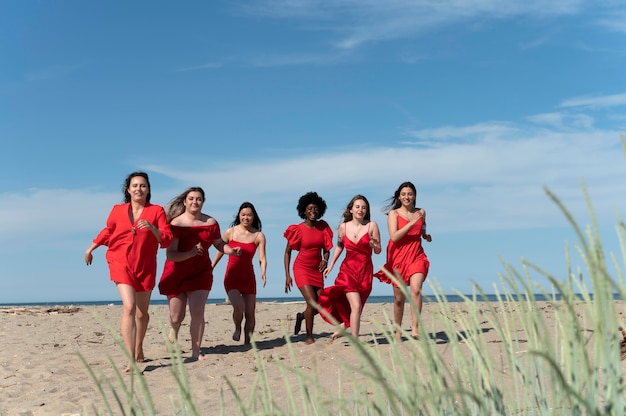 Full shot women running on beach