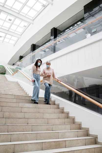 Free Photo full shot women walking down on stairs