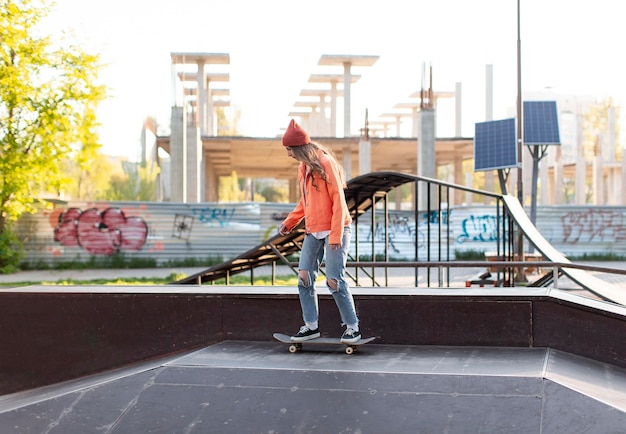 Full shot young girl on skateboard outside