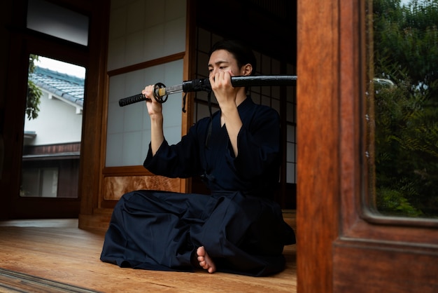 Free photo full shot young man holding sword