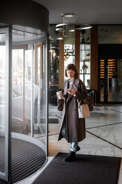 Full shot young woman checking her phone